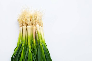 Beyaz arka planda genç yeşil sarımsak