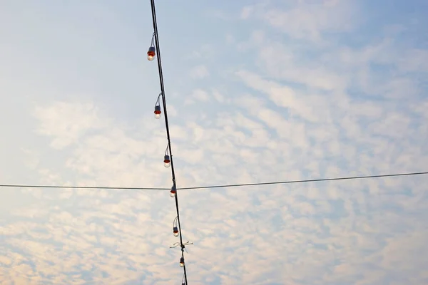 Light bulbs on string wire with blue sky