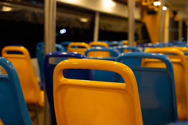 Yellow and blue seats in a ferry boat at night