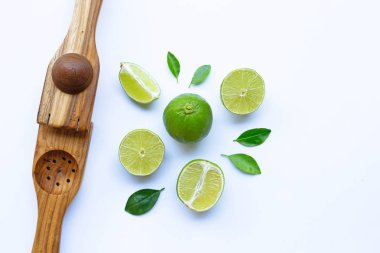 Beyaz arka plan üzerinde ahşap limon sıkacağı ile Limes