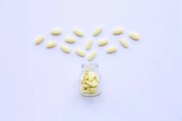 Vitamín C láhev a prášky na bílé — Stock fotografie