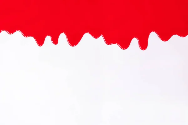 Pintura roja goteando sobre un blanco . — Foto de Stock