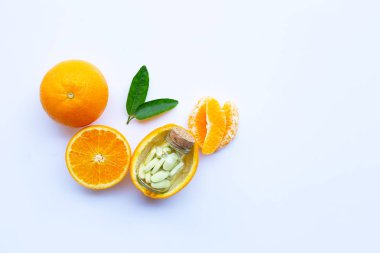 C vitamini şişe ve beyaz arka plan üzerinde turuncu meyve haplarla