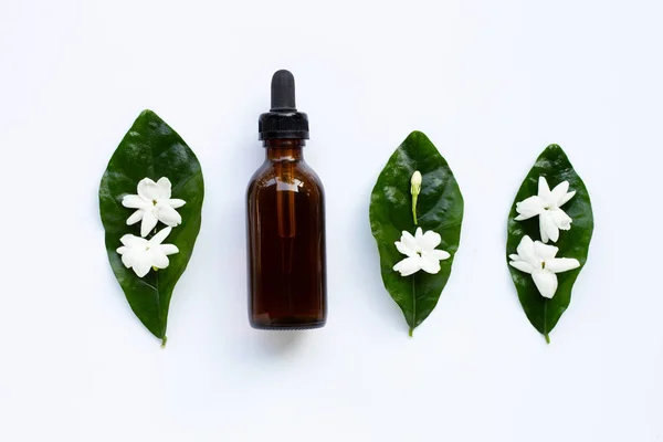 Botella de aceite esencial con flor de jazmín y hojas en blanco . —  Fotos de Stock