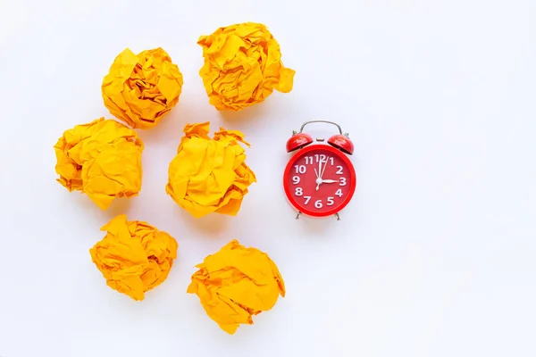 Red alarm clock ring  with yellow crumpled paper ball isolated o — Stock Photo, Image