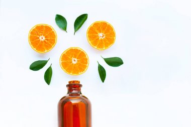 Yüksek C vitamini, beyaz üzerinde esansiyel yağ şişesi ile portakal meyveleri