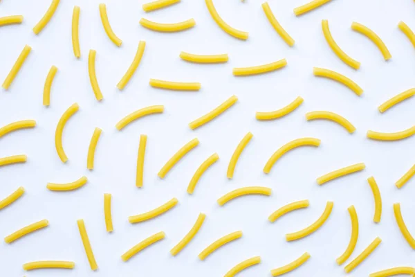 Uncooked macaroni on a white white — Stock Photo, Image