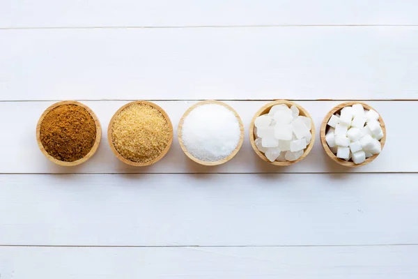Varios tipos de azúcar en madera blanca — Foto de Stock