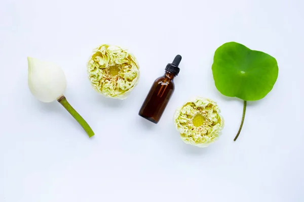 Эфирное масло лотоса с цветами лотоса на белом — стоковое фото