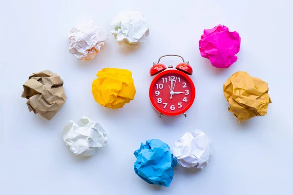 Red alarm clock ring with  colorful crumpled paper ball isolated — Stock Photo, Image