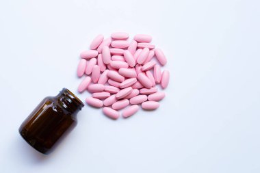 Pembe ilaç hapları ile şişe 