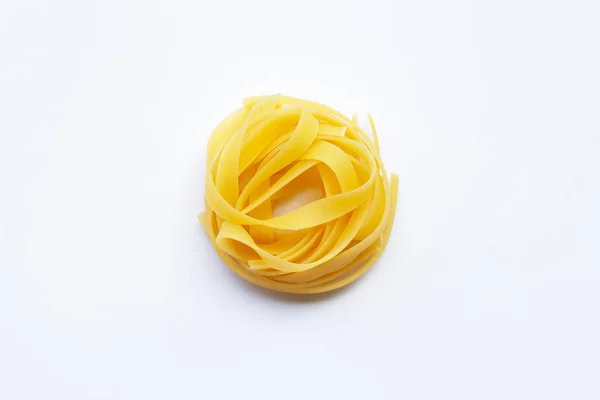 Nido de tagliatelle de pasta italiana sin cocer sobre fondo blanco —  Fotos de Stock