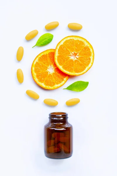 Frasco de vitamina C y pastillas con fruta naranja en blanco —  Fotos de Stock