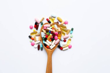 Beyaz üzerinde kapsül ve hap ile renkli tabletler.