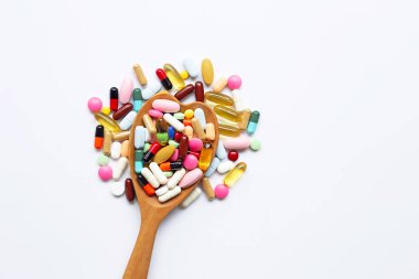 Beyaz üzerinde kapsül ve hap ile renkli tabletler.