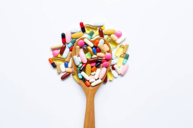 Beyaz üzerinde kapsül ve hap ile renkli tabletler.