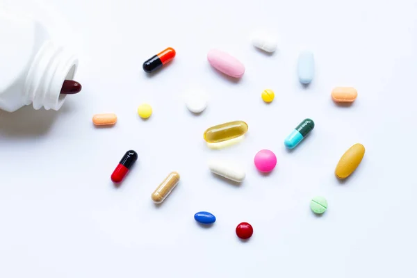 Färgglada tabletter med kapslar och tabletter på vit. — Stockfoto