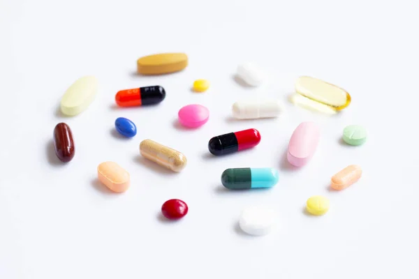 Färgglada tabletter med kapslar och tabletter på vit. — Stockfoto
