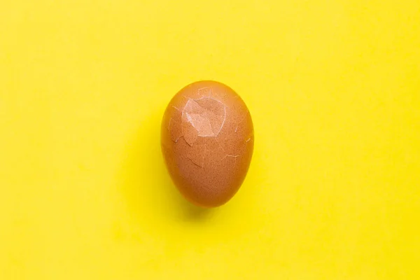 Cracked egg on yellow background — Stock Photo, Image