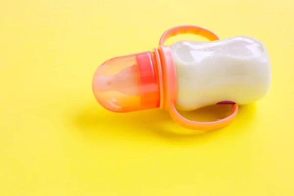 Flasche Milch für Baby auf gelbem Hintergrund. — Stockfoto