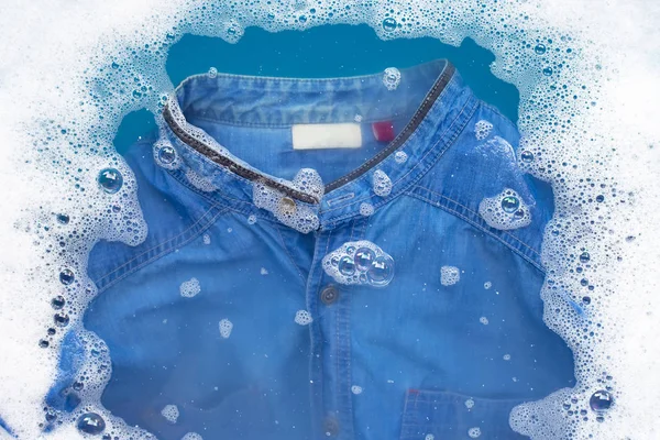 Camicia Jean immersa nella dissoluzione dell'acqua detergente in polvere. Lavanderia — Foto Stock