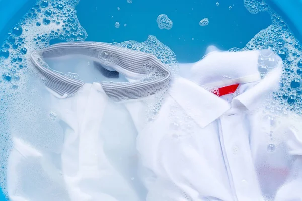 Blanco polo camisas remojo en polvo detergente disolución de agua, wa — Foto de Stock