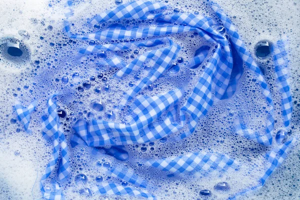 Blau weiße Tischdecke in Pulverwaschmittel Wasser auflösen — Stockfoto