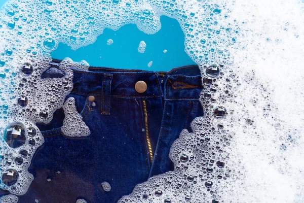 Jeans soak in powder detergent water dissolution. Laundry concep
