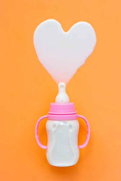 Бутылка Молока Ребенка Оранжевом Фоне Форма Молочного Сердца Вид Сверху — стоковое фото