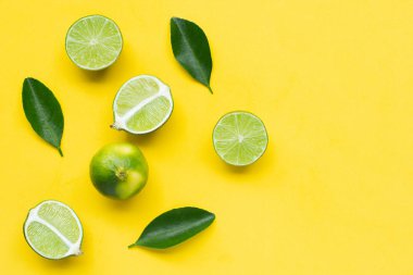 Sarı arka planda yapraklı kireçler.