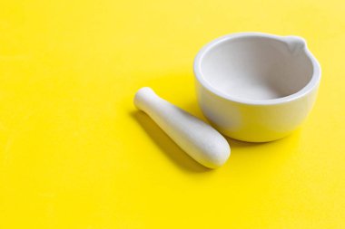 Sarı arka planda harç ve havaneli. 