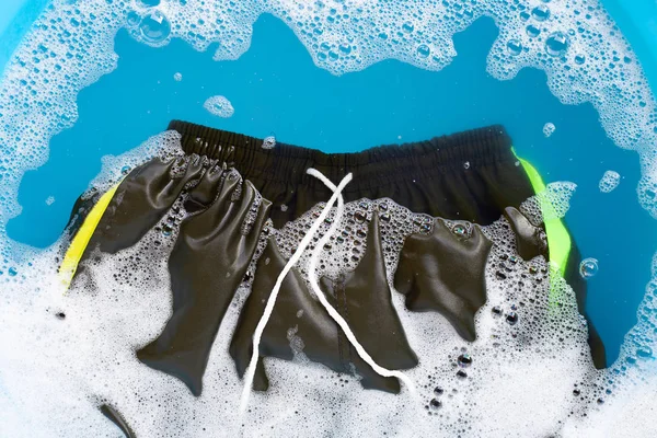 Männliche Shorts in Pulverwaschmittel Wasserauflösung einweichen. Wäscherei — Stockfoto