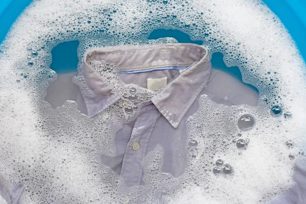 Camisa gris empapar en polvo detergente agua disolución, lavado — Foto de Stock