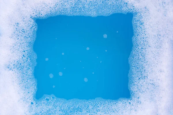 Quadro feito de bolha de espuma detergente. Fundo azul . — Fotografia de Stock