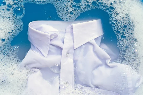 Camisa blanca empapar en polvo detergente disolución de agua. Lavandería — Foto de Stock