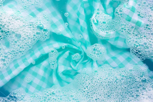 Grön vit bordsduk blöt i pulvertvättmedel vatten dissolutio — Stockfoto
