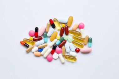 Beyaz üzerinde kapsül ve hap ile renkli tabletler.