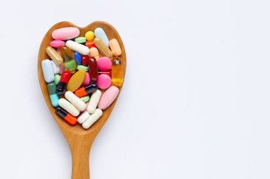 Beyaz arka planda kapsüller ve haplar ile renkli tabletler. Wo