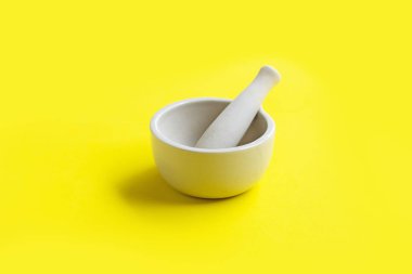 Sarı arka planda harç ve havaneli. 