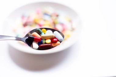 Beyaz üzerinde kapsül ve hap ile renkli tabletler.