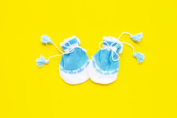 Baby-Handschuhe auf gelbem Hintergrund. — Stockfoto