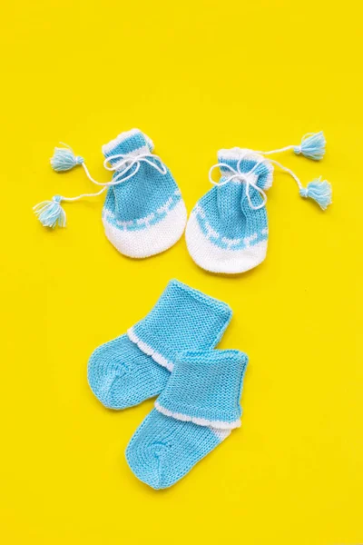 Guantes y calcetines de bebé sobre fondo amarillo . — Foto de Stock