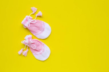 Sarı arka planda bebek eldivenleri.