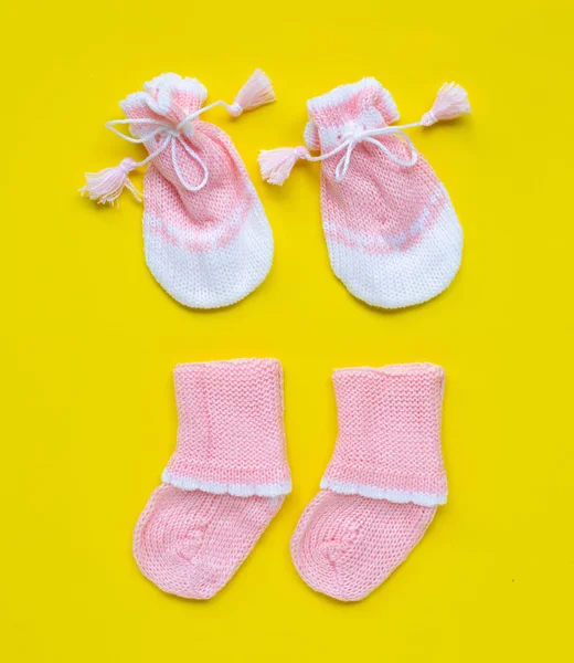 Gants et chaussettes bébé sur fond jaune . — Photo