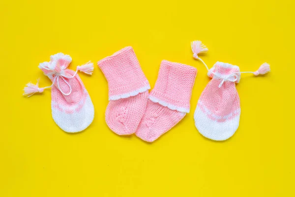 Gants et chaussettes bébé sur fond jaune . — Photo