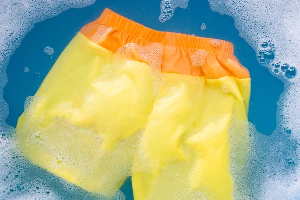 Gul och orange baby shorts blöt i baby tvättmedel Wat — Stockfoto