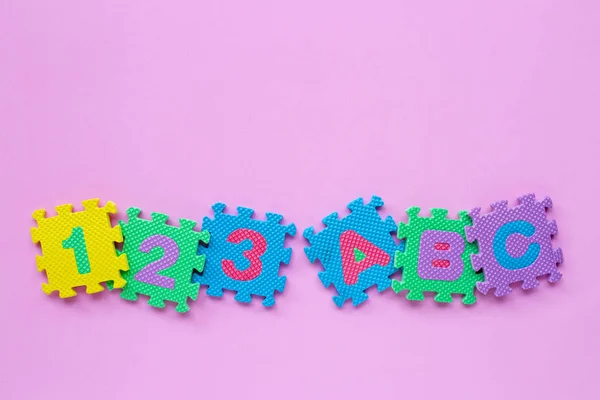 Alphabet puzzle with number puzzle on pink background. — Stock Photo, Image