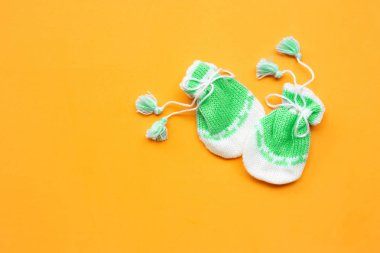 Turuncu arka planda bebek eldivenleri. 