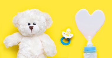 Yello üzerinde oyuncak ayı ile bebek ve bebek emzik için süt Şişesi