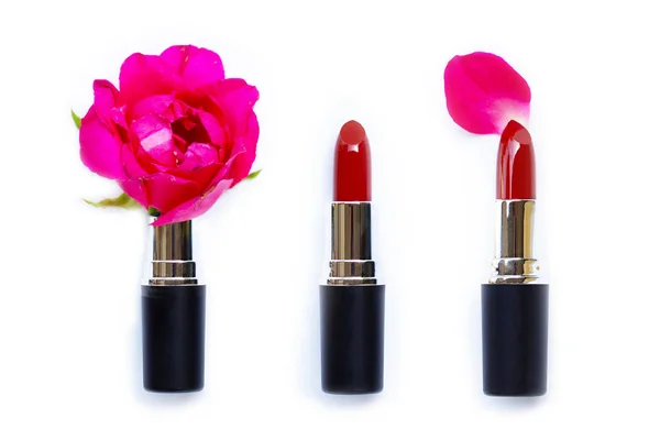 Lippenstifte mit Rosenblüte auf weißem Hintergrund. — Stockfoto